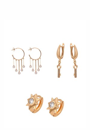 Trzy pary złotych kolczyków: koła z wiszącymi perłami, koła z zawieszkami w kształcie kluczy oraz kolczyki w kształcie gwiazd z przezroczystymi kamieniami w środku.