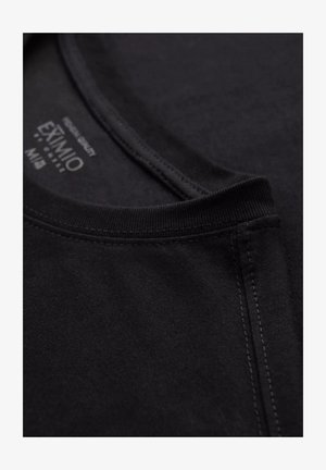 Svart bomull T-shirt med krage som har en slät yta, rund halsringning och förstärkt söm. Taggen visar varumärkesinformation.