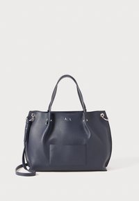 Marineblå strukturert lær tote bag med doble håndtak, frontlomme, sølvfarget A|X-logo og justerbar skulderrem på hvit bakgrunn.