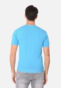 Maglione azzurro chiaro a maniche corte realizzato in materiale a maglia. Presenta un collo rotondo e bordi a costine. Design semplice senza fantasie.