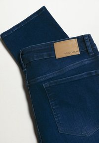 Dark blue denim jeans with a brown leather label on the waistband. Features include five pockets and a straight-leg design.