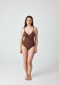 Brauner Einteiler-Badeanzug mit dünnen, verstellbaren Trägern, einem tiefen Ausschnitt und einem taillierten Schnitt, der der Körperform folgt.