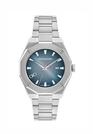 Sølvfarvet rustfrit stål Ferragamo armbåndsur med ottekantet ramme, blå tekstureret urskive, sølvfarvede timeindikatorer, datovindue og ledet armbånd.