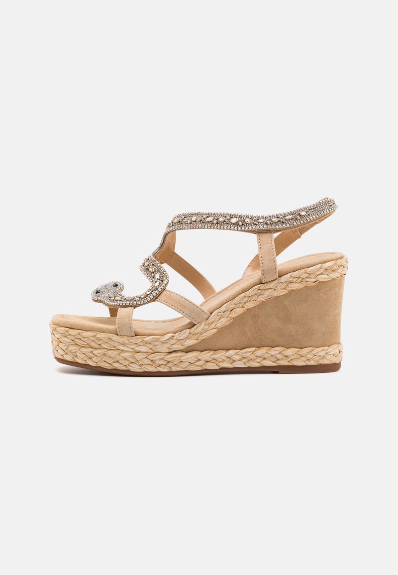 Sandalo con zeppa beige caratterizzato da una parte superiore in suede liscia, dettagli metallici, una piattaforma in juta intrecciata e un design open toe.