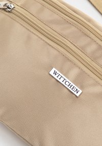Borsa in tessuto beige con texture, caratterizzata da due cerniere e un'etichetta argentata WITTCHEN. Forma rettangolare compatta con dettagli lisci.
