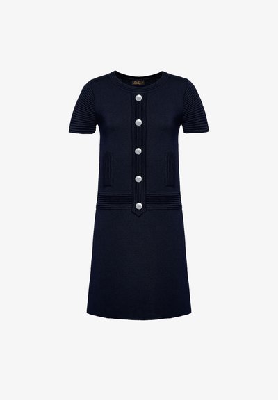 Trikotska obleka v temno modri barvi s kratkimi rokavi, rebrasto teksturo na ramenih, petimi srebrnimi gumbi, dvema sprednjima žepoma, A-linijo in okroglo ovratnico.