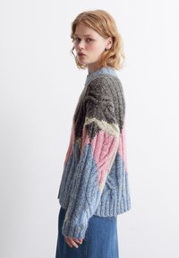 Strickpullover mit geometrischem Design in Blau-, Pink-, Grün- und Grautönen; verfügt über einen gerippten Saum und lange Ärmel, strukturiertes Garn.