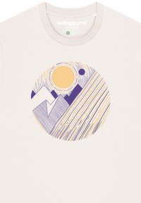 T-shirt beige clair avec un graphisme circulaire représentant un soleil, une lune, des montagnes, et des lignes en violet et orange. Texture de tissu douce.