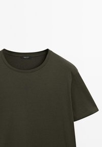 T-shirt en coton vert foncé uni avec col rond et manches courtes, présenté à plat sur fond blanc.