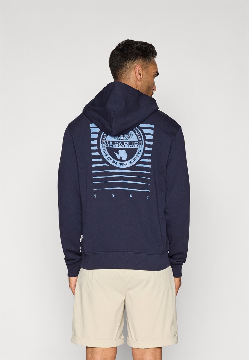 Felpa blu navy con tessuto texturizzato, caratterizzata da un design grafico blu chiaro, strisce e il testo "NAPAPIJRI GPS 1987" sul retro.