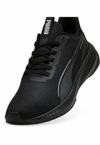 Black athletic shoe with a mesh upper, textured side panels, and a rubber sole. Features laces and a branded pull tab on the tongue.