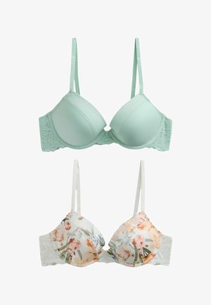 Dve vystužené podprsenky vedľa seba, jedna jednobarevná svetlozelená s čipkovými bočnými časťami a druhá biela s viacfarebným kvetinovým vzorom a čipkovými bočnými časťami, obe s nastaviteľnými ramienkami.