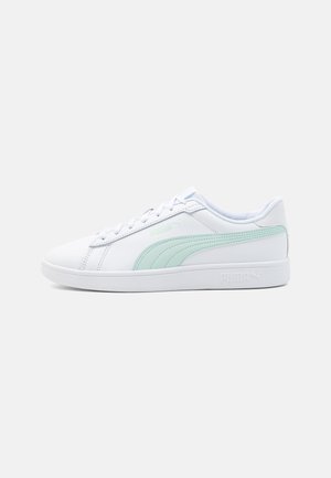 Sneaker bianca basse con striscia Puma verde chiaro e lacci bianchi, vista di lato su sfondo chiaro e uniforme.
