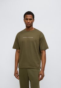 Λαδί βαμβακερό t-shirt με στρογγυλή λαιμόκοψη και κοντά μανίκια. Φέρει το λογότυπο "TOMMY HILFIGER" στο κέντρο του στήθους.