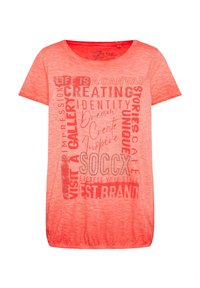 Camiseta de manga corta y cuello redondo en un vibrante color coral. Presenta diferentes impresiones de texto en gris y blanco, incluyendo "SOCCX" y frases inspiradoras.