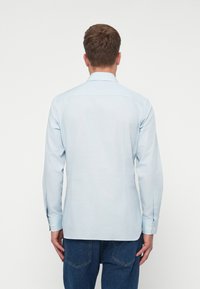 Lyseblå langermet skjorte med kneppingkrage, laget av glatt stoff, med ensfarget design og knappefester.