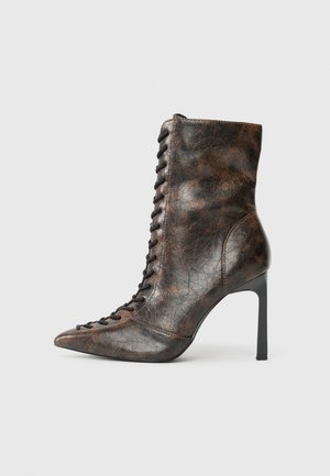 Brown leather ankle boot with a pointed toe and high stiletto heel. Features front lacing and a textured finish in a crinkled pattern.