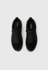 Ghete din suede negre cu sireturi negre, fermoare pe părțile laterale și detalii texturate pe toc. Talpă plată din cauciuc.