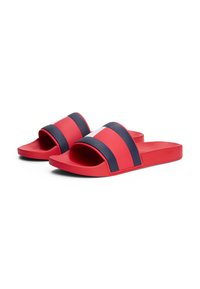 Sandales rouges avec deux rayures marine sur le dessus, fabriquées en caoutchouc lisse. Semelle plate, design ouvert au niveau des orteils et semelle intérieure texturée pour une bonne adhérence.