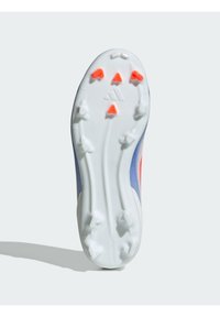 White football boot sole with red and orange studs. Features a smooth texture, contoured shape, and an angled design for traction.