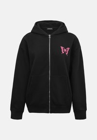 Sweat à capuche noir zippé avec un motif de papillon rose sur le côté gauche de la poitrine. Dispose d'une capuche et de poches avant. Fabriqué en tissu doux.