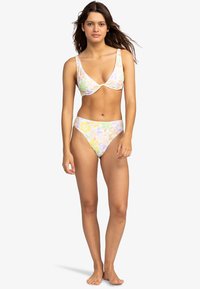 Flerfärgad blommig bikiniuppsättning med djup urringad bralette och högmidjade trosor, tillverkad av mjukt, elastiskt tyg.