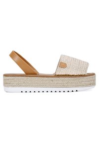 Sandalia de estilo espadrille con parte superior de tejido crema, tira de cuero marrón y suela de yute texturizado, que presenta una parte inferior de goma blanca.