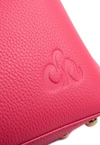 Borsa in pelle textured rosa con logo goffrato tonale; dettagli in hardware dorato alla base e cuciture lisce lungo i bordi.