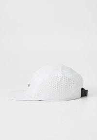 White cap with a textured front and perforated back. Features a flat brim and an adjustable strap on the side. Simple logo detail.