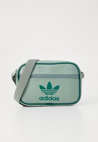 Borsa a tracolla sintetica verde con compartimento con zip, dotata di logo Adidas ricamato e spallaccio sottile.