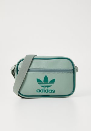Zelená syntetická crossbody taška se zipovou kapsou, vyšívaným logem Adidas a úzkým ramenním popruhem.