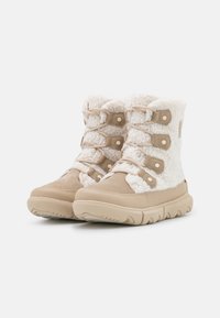 Beige vinterstøvler med overdeler i kunstpels, snøring med fem øyer og en teksturert gummisåle for bedre grep.