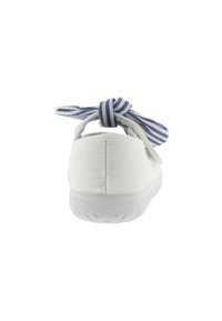 Zapatilla de lona blanca con punta redonda y suela de goma texturizada. Presenta un lazo a rayas azules y blancas en la parte trasera para un ajuste seguro.