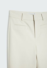 Beige op maat gemaakte broek met een rechte snit, voorzien van twee voorzakken, nette stiksels en een gladde stoftextuur.
