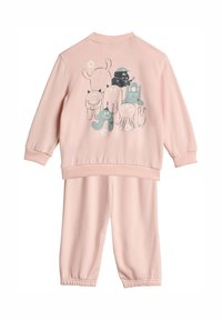 Růžová souprava s mikinou a kalhotami. Na zadní straně se nacházejí postavičky v kresleném stylu v černé a tyrkysové barvě, má žebrovaný límec a elastické manžety.