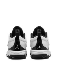 Zwart-witte sport schoenen met een gestructureerde bovenkant, een gevoerde kraag en een opvallend logo op de hiel. Versterkte rubberen buitenzool voor grip.