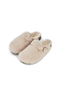 Sabots en beige flou avec une texture douce et une forme arrondie, ornés d'un nœud décoratif et d'une semelle en caoutchouc noir pour une bonne adhérence.
