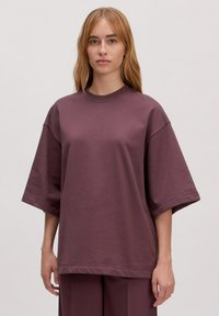 Overzichtelijk, kort mouw t-shirt in diep mauve, gemaakt van zacht katoen, met een ronde hals en een relaxte pasvorm, rechte zoom, minimale naden.