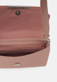 Różowa torebka materiałowa z srebrną klamrą, wewnętrzną kieszenią na zamek oraz gładką fakturą. Charakteryzuje się usztywnionym kształtem i krótkim paskiem na ramię.
