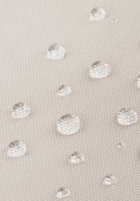 Beige vattentätt tyg med synliga vattendroppar, som har en texturerad yta och ett tätt vävt mönster.