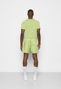 Nike Sportswear M NSW SPE WVN LND FLOW SHORT - Spodnji deli trenirk - vivid green/white