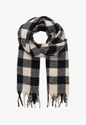 Écharpe en laine à carreaux noirs et blancs avec extrémités à franges, pliée en boucle sur un fond blanc.