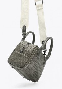 Borsa a mano grigia intrecciata con doppi manici superiori, tracolla bianca regolabile, chiusura con zip e logo sottile. Presenta una forma cubica strutturata e una finitura testurizzata.