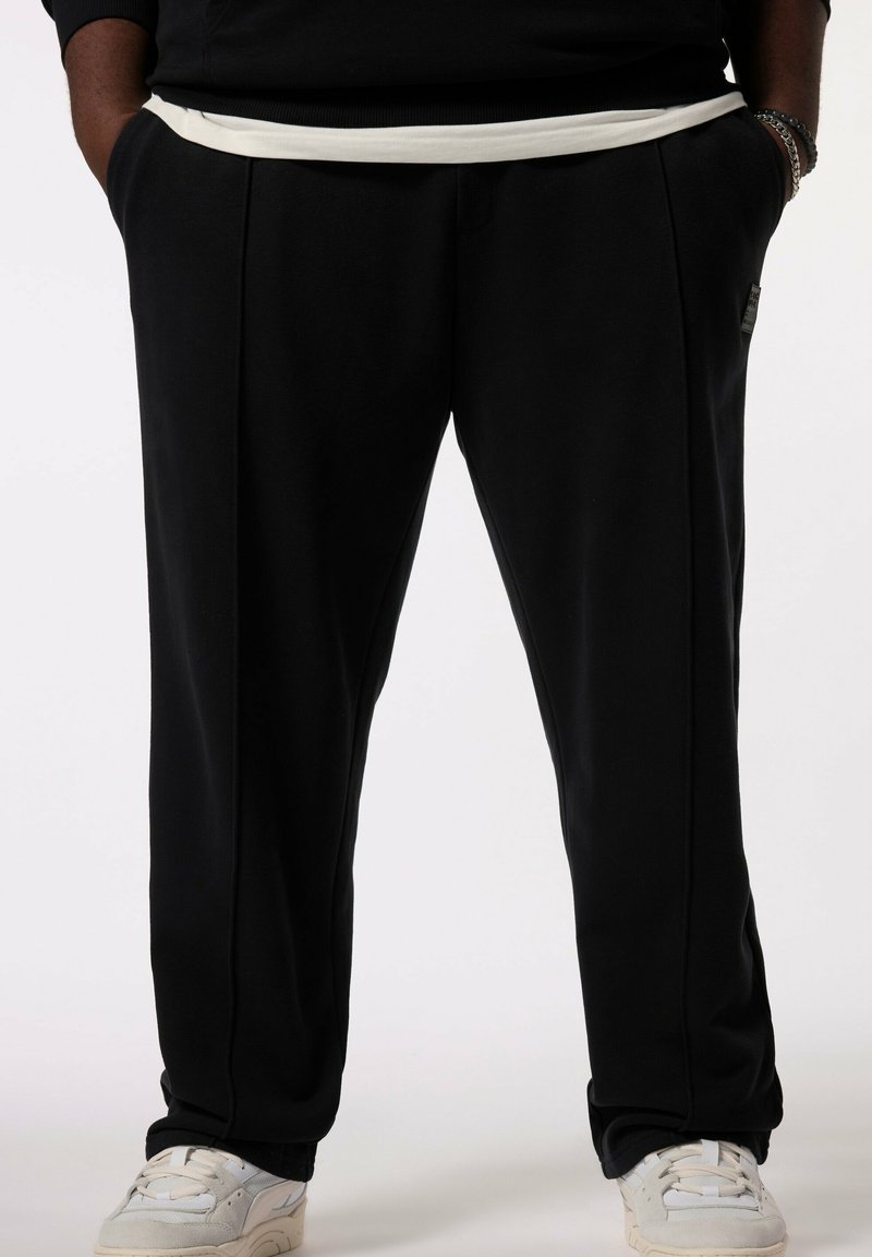 Sorte sweatpants med en hvid elastisk talje, der har sidelommer, en lige pasform og diskrete syninger.