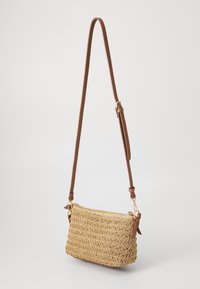 Vävd halm crossover-väska med ett brunt läderrem och detaljer i guldton. Väskan har ett dragkedjestängning och en texturerad design.