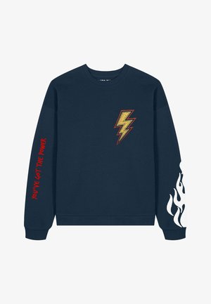 Sweat-shirt bleu marine en coton, doté d'une broderie d'éclair doré et d'un texte rouge "TU AS LE POUVOIR" sur la manche, avec un motif de flammes blanches.