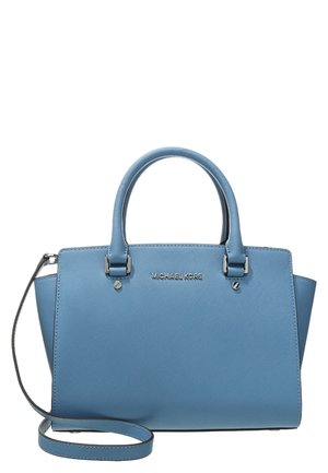 Sac à main bleu Michael Kors avec deux poignées, une bandoulière amovible et une surface en cuir texturé.