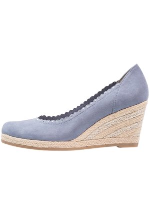 Zapato con cuña en ante azul claro con detalle de borde ondulado. Cuenta con tacón envuelto en yute y punta cerrada. Suela plana de goma.