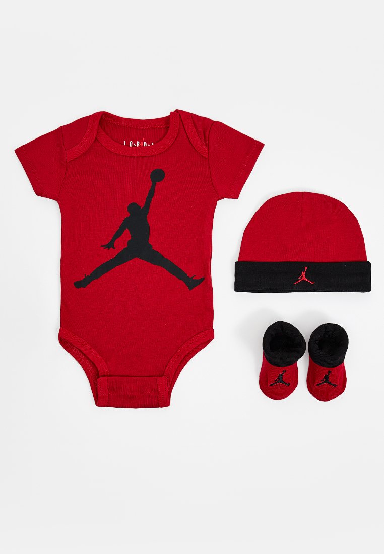 Monosie rojo de manga corta con el logo negro de "Jumpman", gorro rojo a juego con banda negra y dos pares de botines negros y rojos.