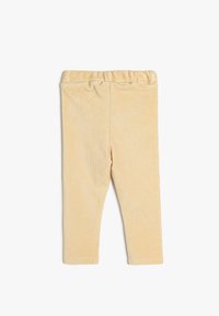 Gule fløjl leggings med en blød tekstur, der har en elastisk talje og en tætsiddende pasform.